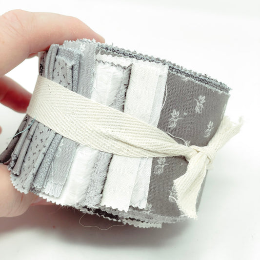 Partial Jelly Roll of Gray Fabric Strips