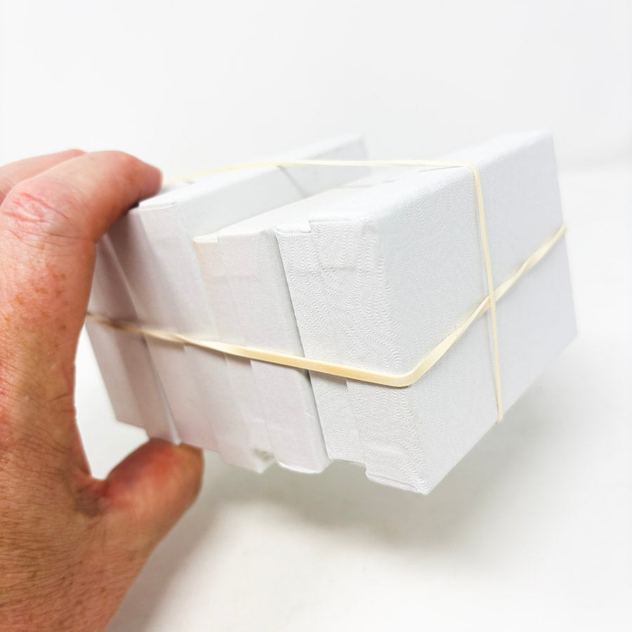 Stack of White Paper Jewelry Boxes with Cotton Inserts