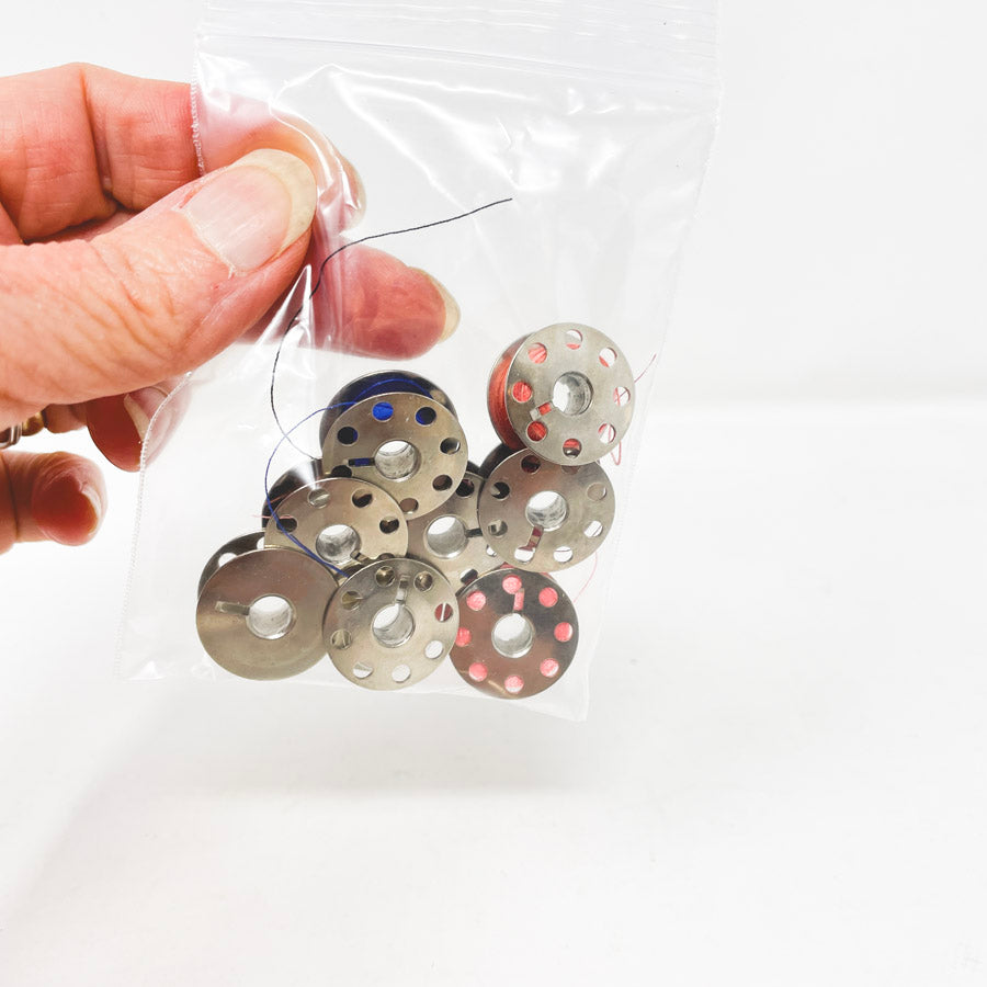 Eight Metal Bobbins